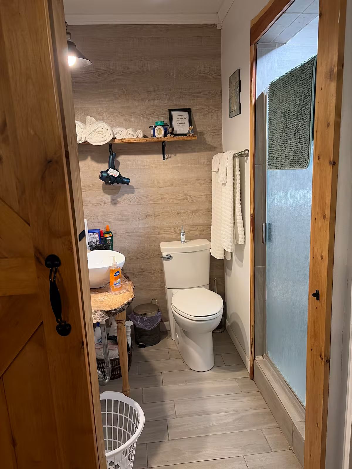 A compact bathroom with a toilet, sink, and shower area.