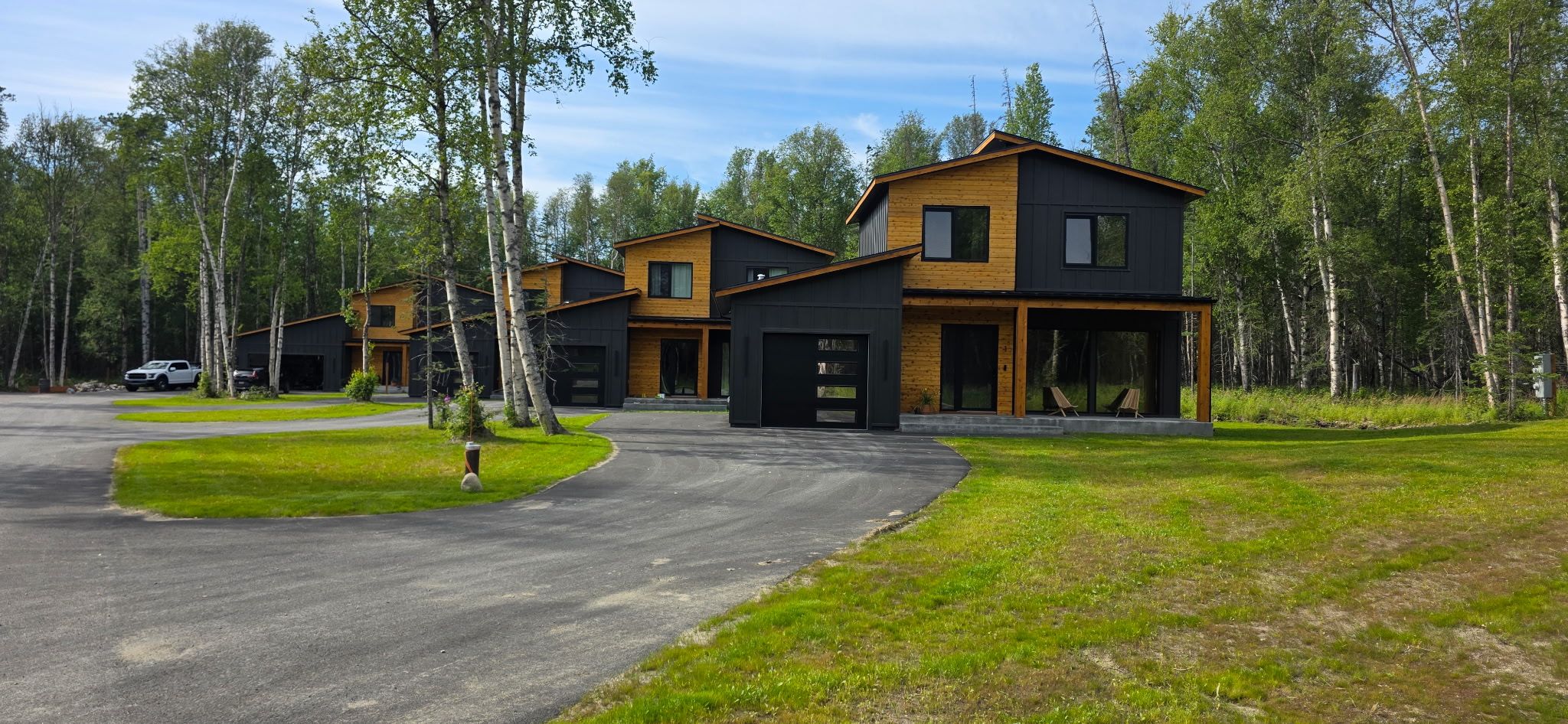 Une maison moderne à deux étages, dotée d’un porche couvert et d’une allée.