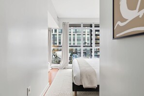 Een moderne hotelkamer met een groot raam, een bed en uitzicht op de stad.