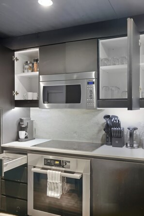 A modern kitchen with a built-in microwave, a coffee maker, and a stainless steel oven. - 3BR/3BA Downtown Toronto + Free Parking | Parking Available (Toronto)