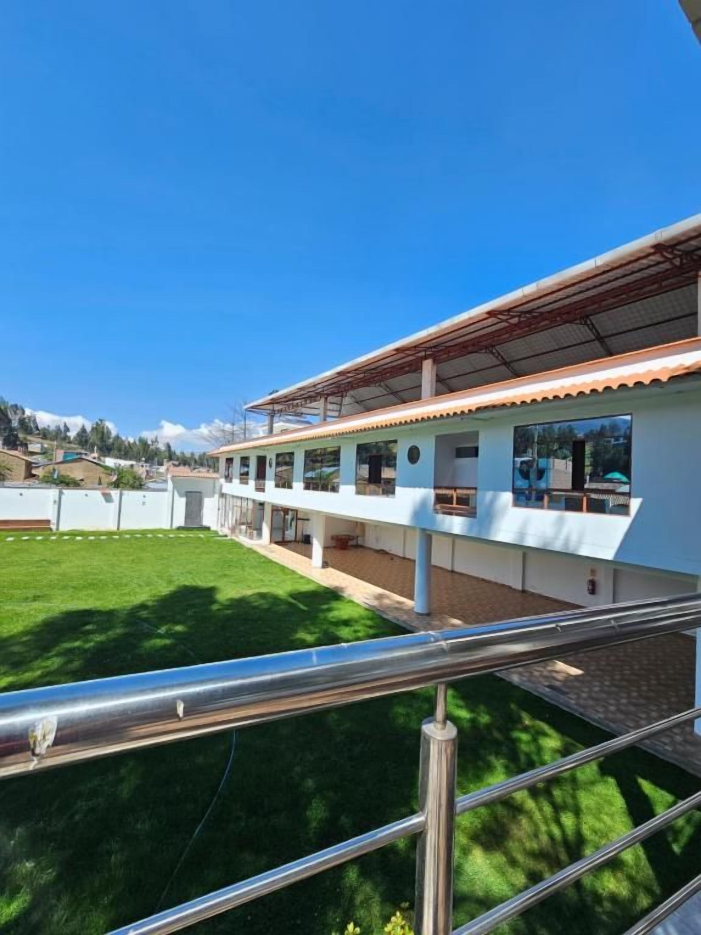 Ein Gebäude mit flachem Dach, zahlreichen Fenstern und einem Balkon.