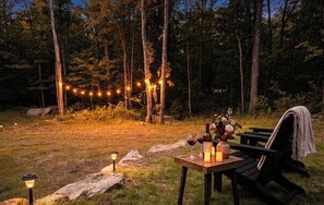 Ein Essbereich im Freien mit einem Tisch für zwei Personen, umgeben von einem Wald.