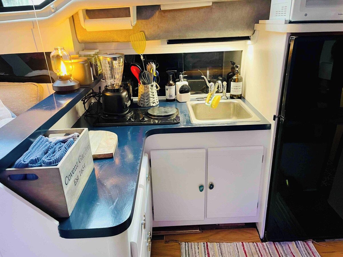 A compact kitchen with a built-in stove, a sink, and a refrigerator.
