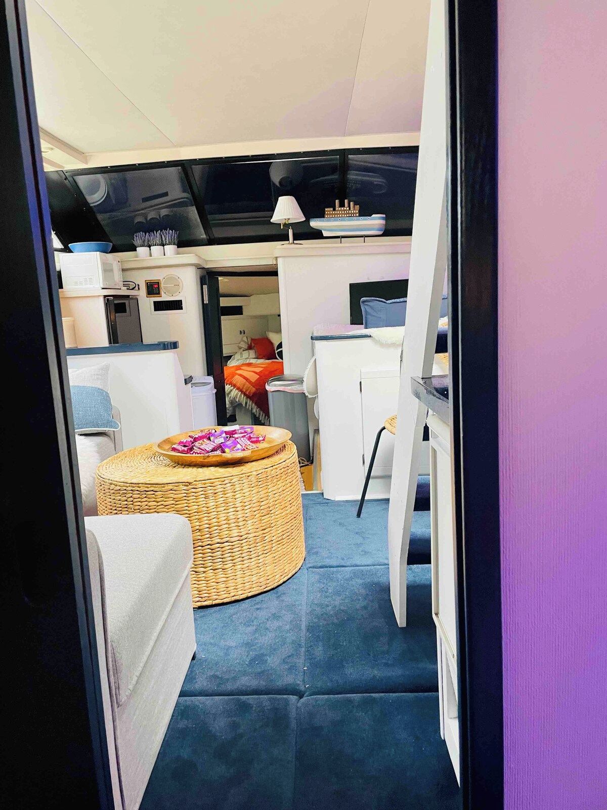 A compact interior with a kitchenette, a dining area, and a bed.