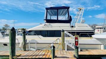 Un yacht était amarré dans une marina, près d’un quai en bois, d’une bouée de sauvetage et d’une échelle.