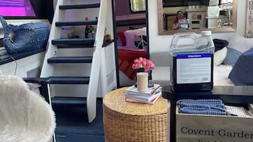 A compact living space with a bunk bed, a kitchenette, and a small dining area.