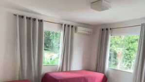 Ein Zimmer mit zwei Betten, einem Schreibtisch und einer Klimaanlage.