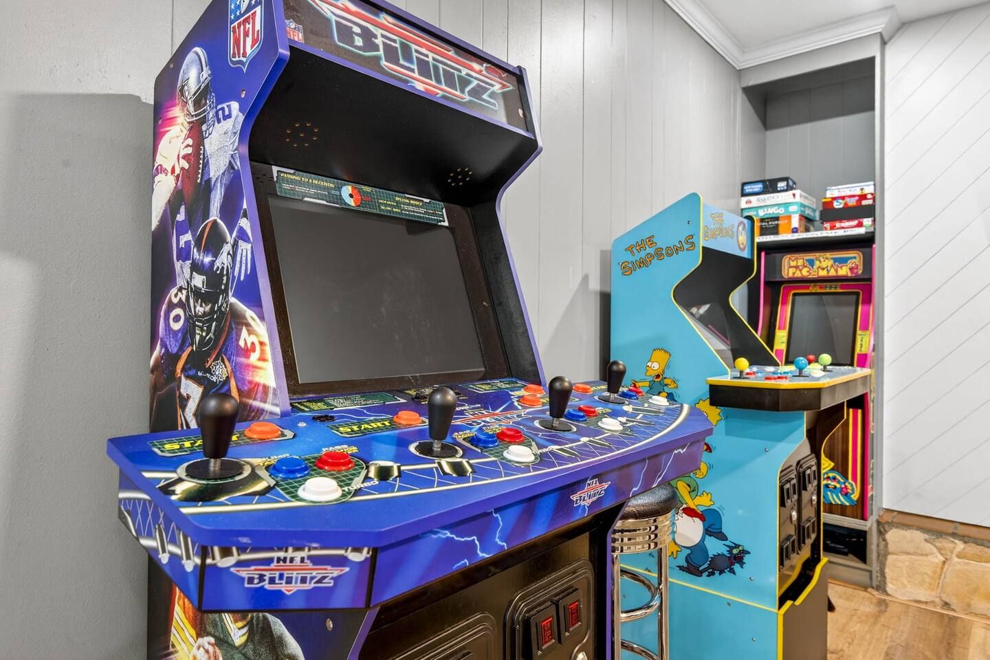 Una sala de juegos con una decoración azul y negra, que presenta un botón de inicio y controles tipo joystick.