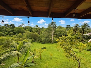 Área externa com teto de madeira e luminárias pendentes.