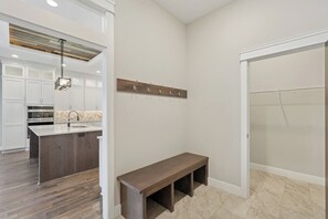 Une cuisine moderne avec des meubles blancs, un îlot central en bois et un four encastré.
