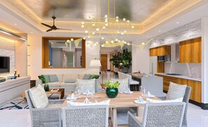 Ein modernes Wohnzimmer mit Essbereich, einer Küche und einem Deckenventilator.