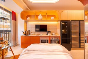 Ein modernes Schlafzimmer mit einem Bett, einem Glastisch und Blick auf die Stadt.