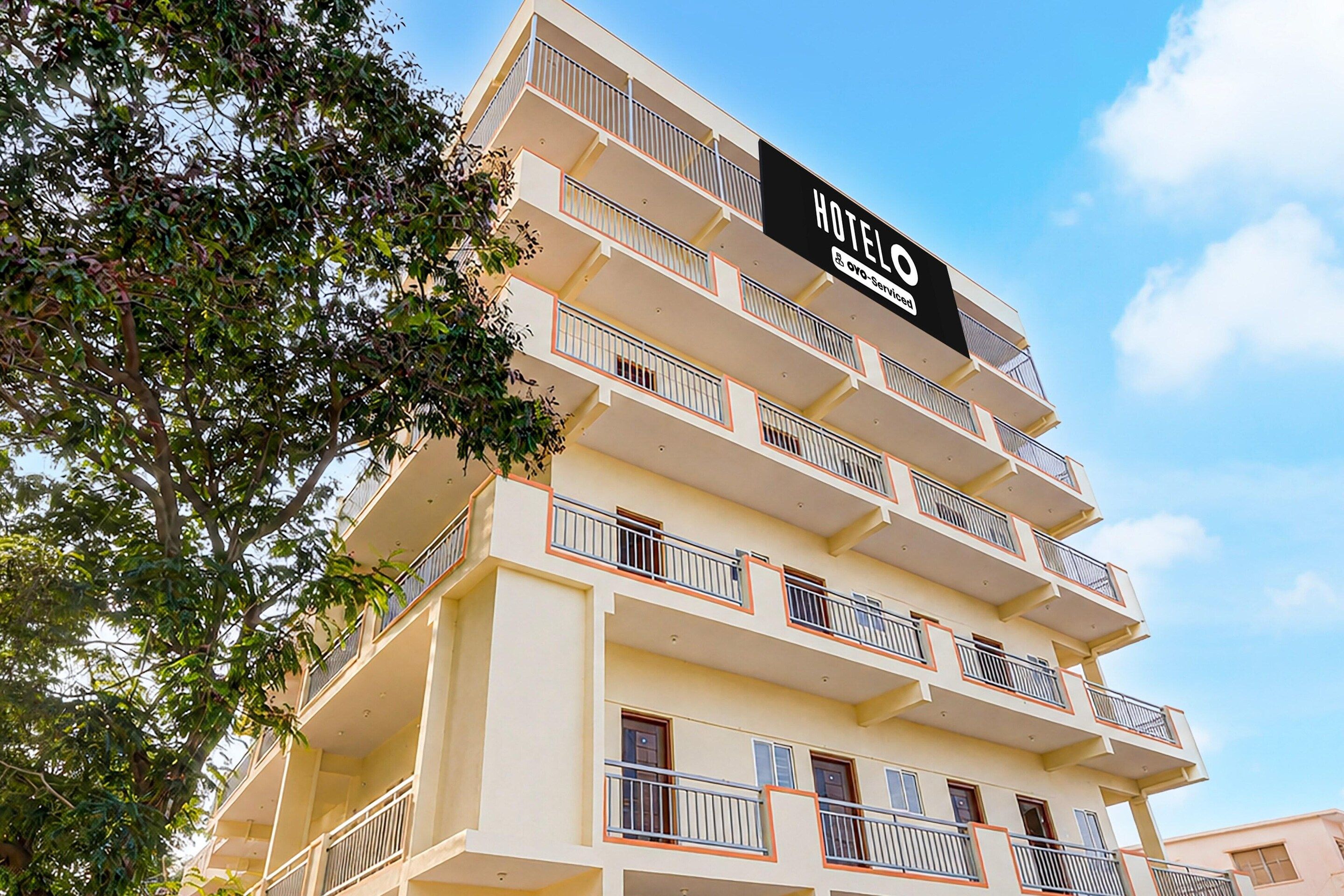 Edifício de hotel com vários andares, varandas e placa indicando que é administrado pela OYO.