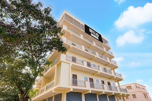 A multi-story hotel building with balconies and a sign indicating it is an 'Ova-Serviced' hotel. - Classic White Field CS (Bengaluru)
