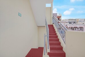 A staircase with red steps and a metal railing leading to an upper level. - Classic White Field CS (Bengaluru)