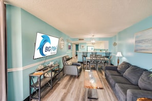 A living room with a sofa, coffee table, and a TV displaying 'BIG FISH Rentals'. - Wonderful 3  bedroom Unit at Sand Dunes Resort (Myrtle Beach)