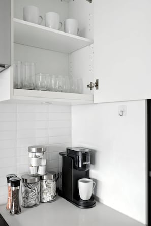 Eine Küche mit Kaffeemaschine, Glasbehältern und einer weißen Tasse.
