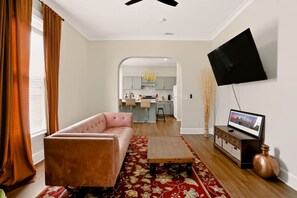 A living room with a sofa, a coffee table, and a flat-screen TV mounted on the wall. - Spacious Herron-Morton Stay Near Downtown (Indianapolis)
