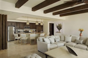 A modern kitchen with a central island, bar stools, and pendant lighting. - Spend Halloween in Cabo 2br/3bth condo Oct 31- Nov 7 (Cabo San Lucas)