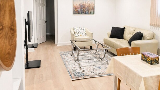 A modern living room with a sofa, armchair, coffee table, and a dining table. - Self-Contained, Full Kitchen, Full Bath, Private-A (Richmond Hill)