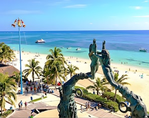 A beach with a statue, palm trees, and a clear blue sea. - Rooftop Pool · 2 Private Apartments · Sleeps 8 · 3 Blue Flag Beaches 15 Min (Playa del Carmen)