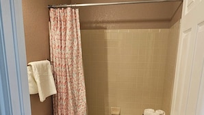 Een kleine badkamer met toilet, wastafel en douche.