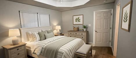 Un dormitorio con cama, mesitas de noche, un abanico de techo, una puerta y una planta enmarcada en la pared.