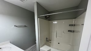 A bathroom with a bathtub, a shower area, and a sink. - 3BR/2BA Near Fort Campbell & Tennova - Fenced Yard, Pet Friendly, Back Patio (Clarksville)