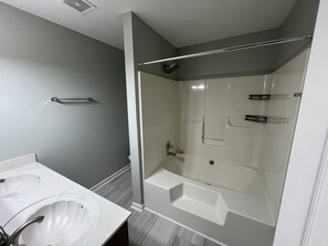 Ein Badezimmer mit einer Badewanne, einer Duschkabine und einem Waschbecken.