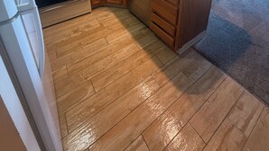 Eine Küche mit Holzausstattung, einem Edelstahlherd und einem Geschirrspüler.
