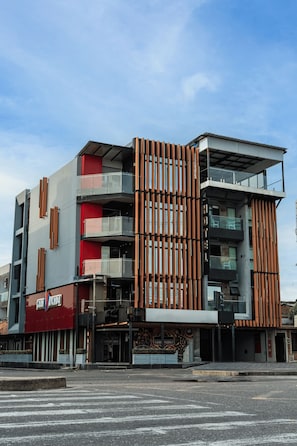 Un edificio moderno de varios pisos con una combinación de balcones y grandes ventanales.
