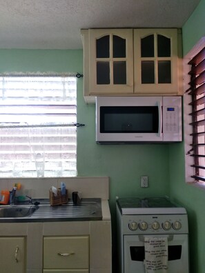 A kitchen with a microwave, oven, and cabinets.