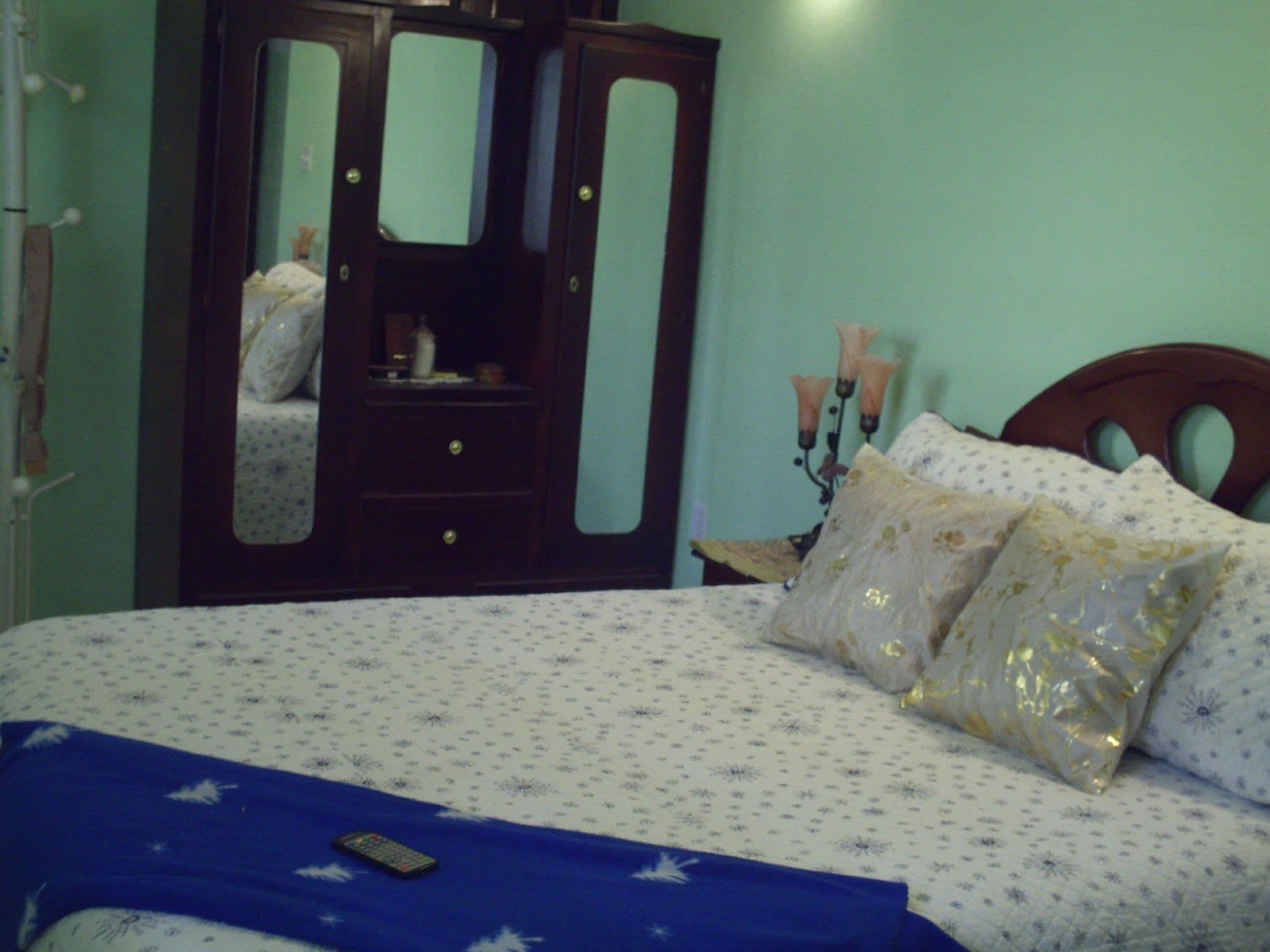 A bedroom with a bed, a dresser, and a mirror.