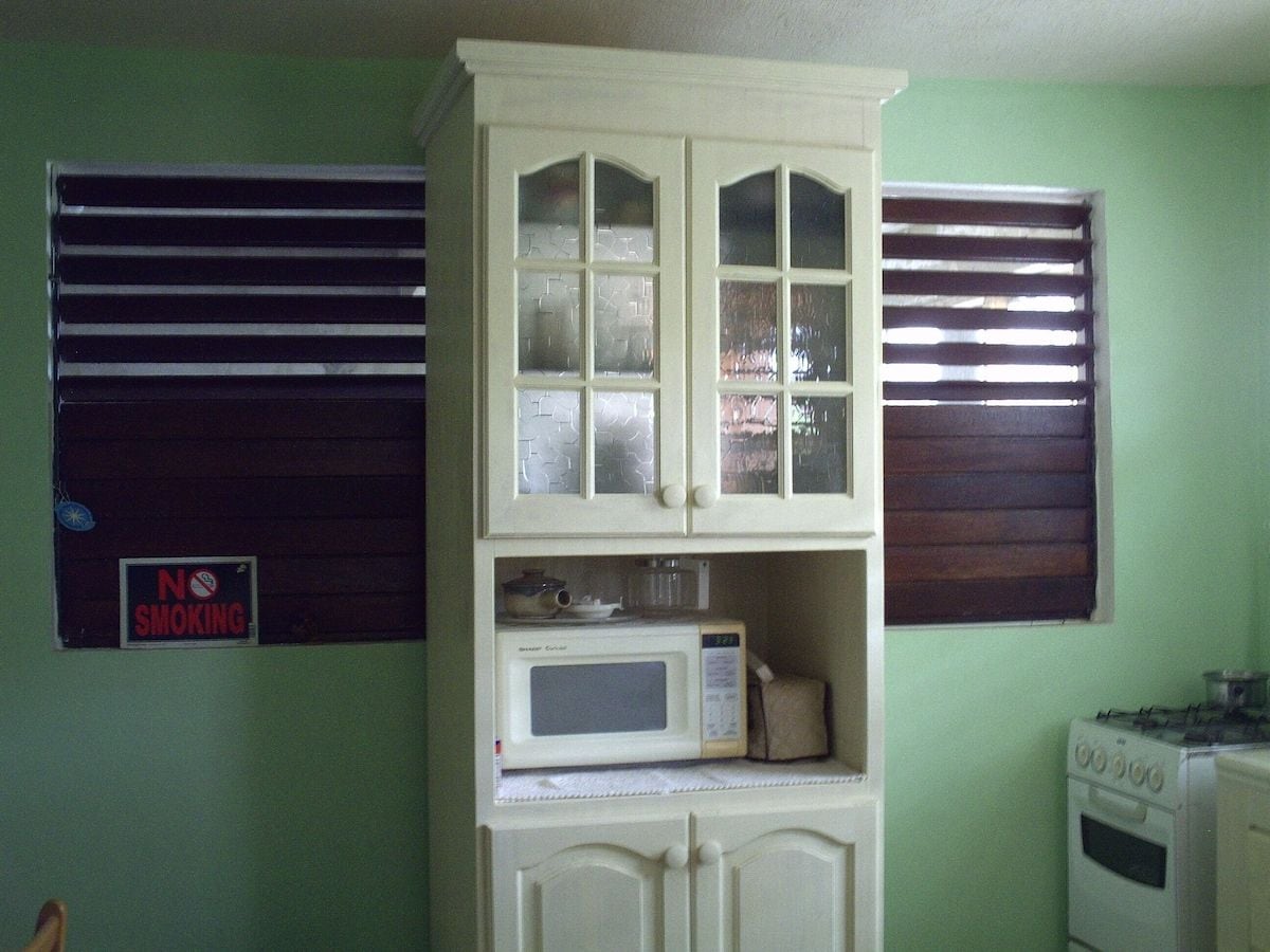 A kitchen with a microwave, stove, and cabinets.