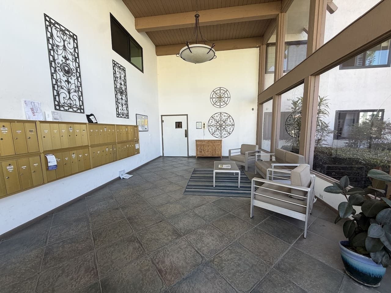 A lobby with a row of lockers, a reception desk, and a seating area with a view of the outdoors.