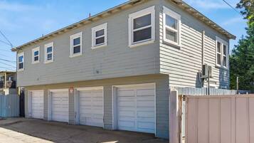 A two-story residential building with a garage and a fenced yard.