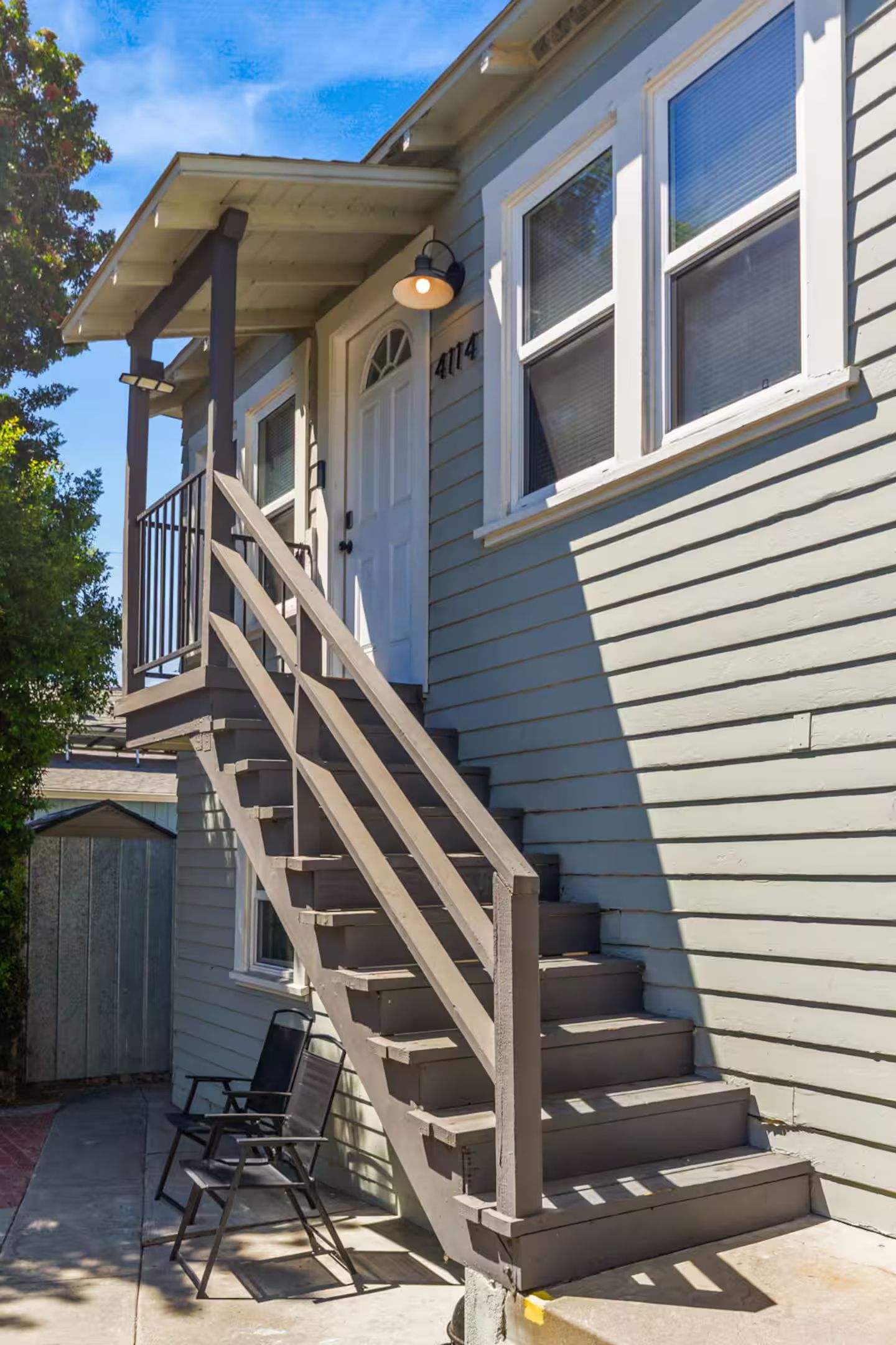 Un immeuble résidentiel doté d’un escalier menant à un porche abrité.