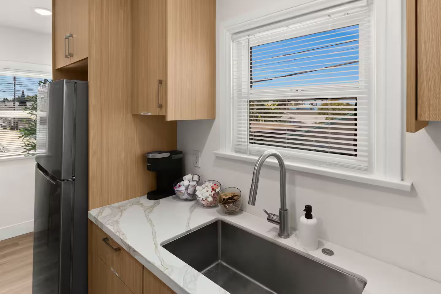 A modern kitchen with a built-in sink, a refrigerator, and wooden cabinets.
