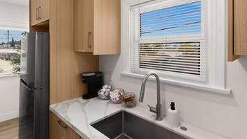 A modern kitchen with a built-in sink, a refrigerator, and wooden cabinets.