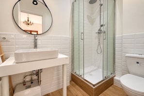 Ein Badezimmer mit einem weißen Waschbecken, einer Duschkabine aus Glas und einer Toilette.