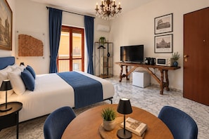 Ein Hotelzimmer mit Bett, Fernseher, Kaffeemaschine, Mikrowelle und Bücherregal.