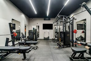 A gym with various exercise equipment, mirrors, and a television screen. - Apartment with heated pool and gym in Alphaville - Barueri - São Paulo (Barueri)