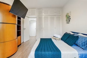 A bedroom with a bed, a wardrobe, and a television. - Apartment with heated pool and gym in Alphaville - Barueri - São Paulo (Barueri)