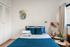 A bedroom with a bed, bedside table, and a potted plant. - Apartment with heated pool and gym in Alphaville - Barueri - São Paulo (Barueri)