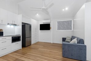 Eine moderne Küche mit weißen Schränken, einem Einbauofen und einem Edelstahlkühlschrank.