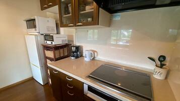 A kitchen with a microwave, coffee maker, and a toaster on the countertop.