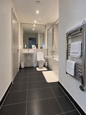 Ein modernes Badezimmer mit Toilette, Waschbecken und Dusche.