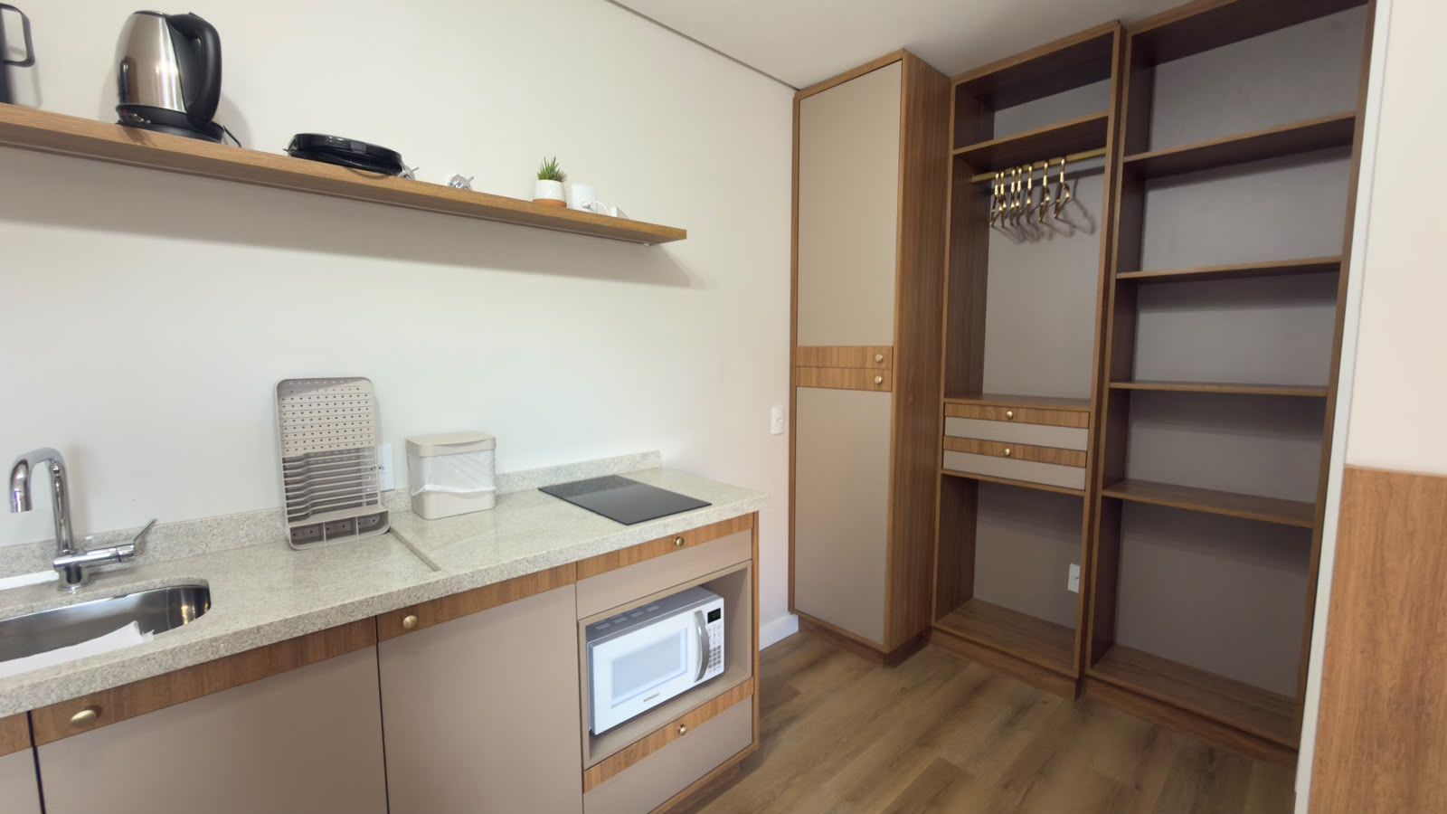 A compact kitchen with a sink, microwave, and a coffee maker.
