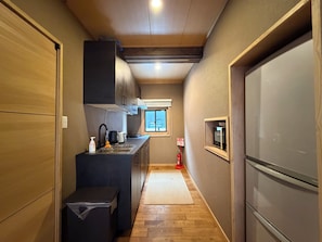 Eine schmale Küche mit einem Einbaukühlschrank, einem Spülbecken und einem Fenster für natürliches Licht.