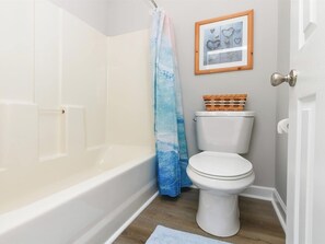 A bathroom with a bathtub, toilet, and a shower curtain. - Large 2BR Unit with Pool Access, River Oaks Golf (Myrtle Beach)